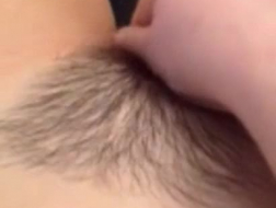 Una ragazza dai capelli corti si sta masturbando sul divano, mentre gioca un po' con la sua fessura.