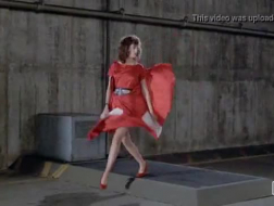 Рыжеволосая женщина носит высокие каблуки и трет свою киску перед камерой.