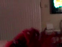 Una ragazza dai capelli rossi, Sarah Banks si sta giocando la figa con un grosso dildo a due punte, in una stanza d'albergo