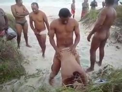 Politieagenten in hete zee die naakt op het strand strippen.